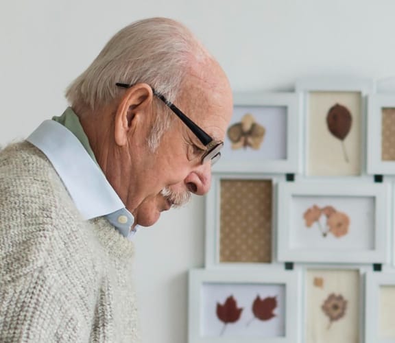 Man standing in front of a collage of fall pictures looking down at the floor